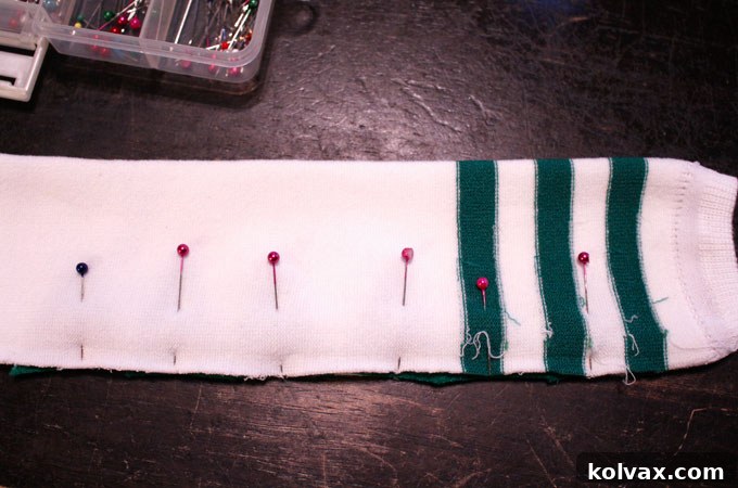 Process photo: Pinning the sock's slit closed with the dinosaur spikes carefully placed inside, ready for sewing.