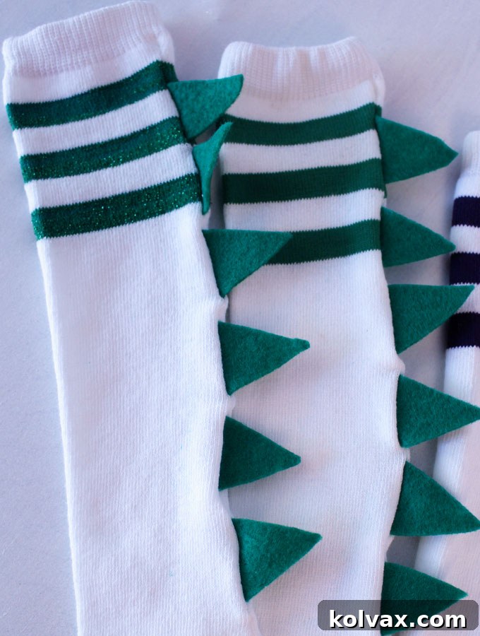 Final step: Turning the completed DIY Dinosaur Socks right side out to reveal the vibrant, securely sewn-in dinosaur spikes along the back.