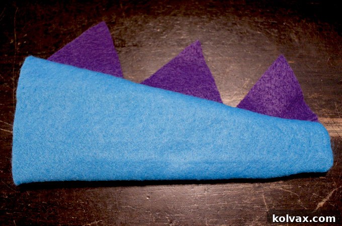 The finished, three-dimensional dinosaur tail with upright felt spikes, ready to be attached to the party favor bag.