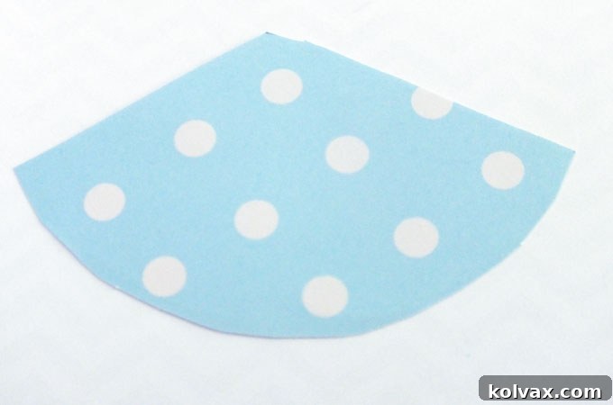 Cutting out the dinosaur party hat template from craft paper with scissors.