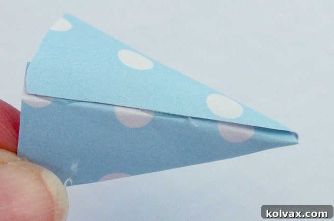 A freshly glued, conical DIY dinosaur party hat.