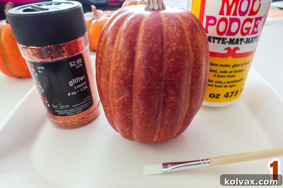 Glamorous Glitter Pumpkin Decor 3 All the supplies you will need to Make DIY Glitter Pumpkins including faux pumpkins, various colors of glitter, Mod Podge, and a craft brush.