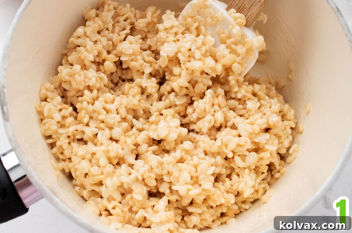 Enchanted Krispie Witch Hats 3 Closeup on a white sauce pan filled with warm Rice Krispie Treat mixture.