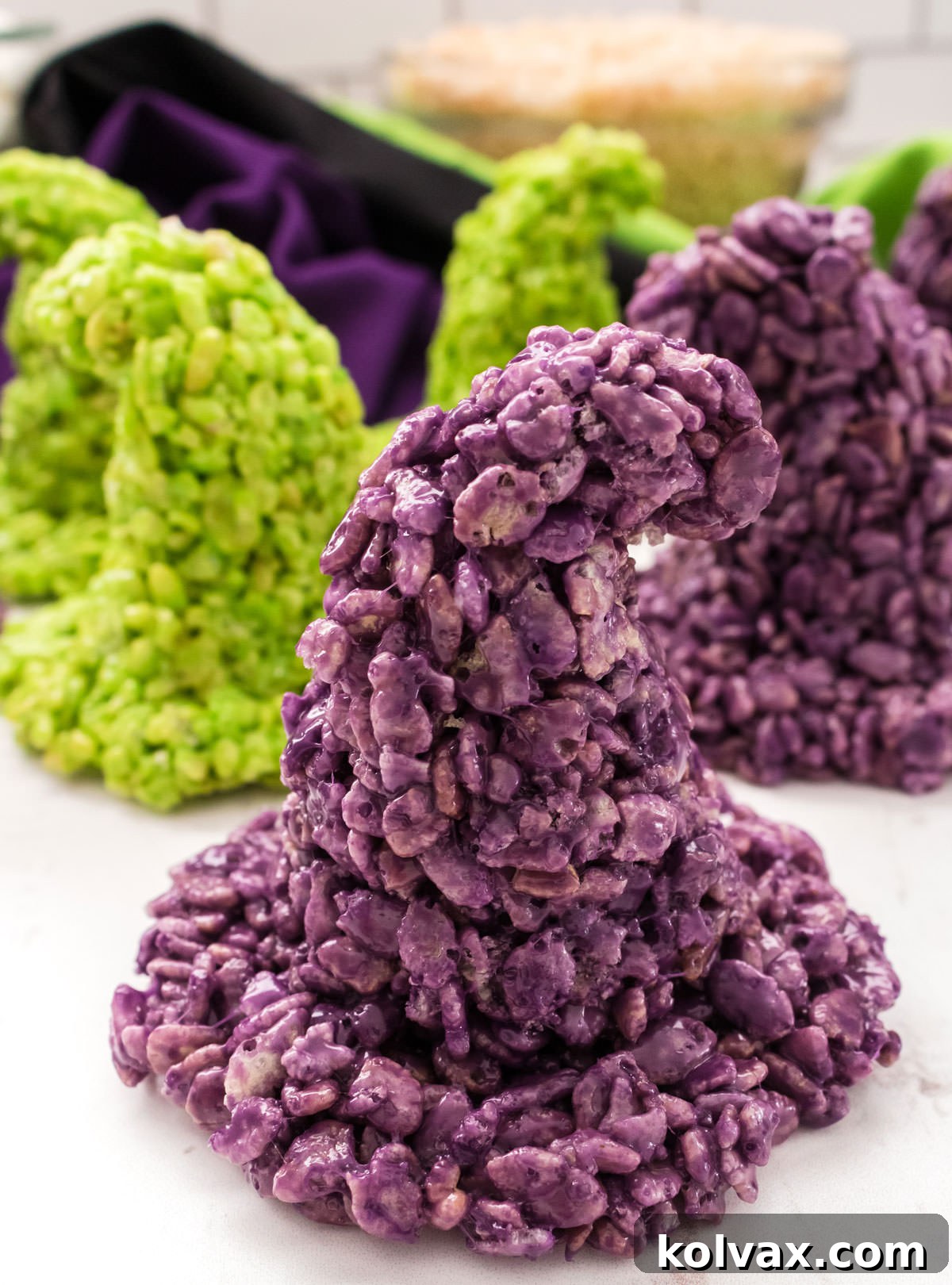 Enchanted Krispie Witch Hats 7 Closeup on a purple Witch Hat Rice Krispie Treat sitting on a white table with more Witch Hats in the background.