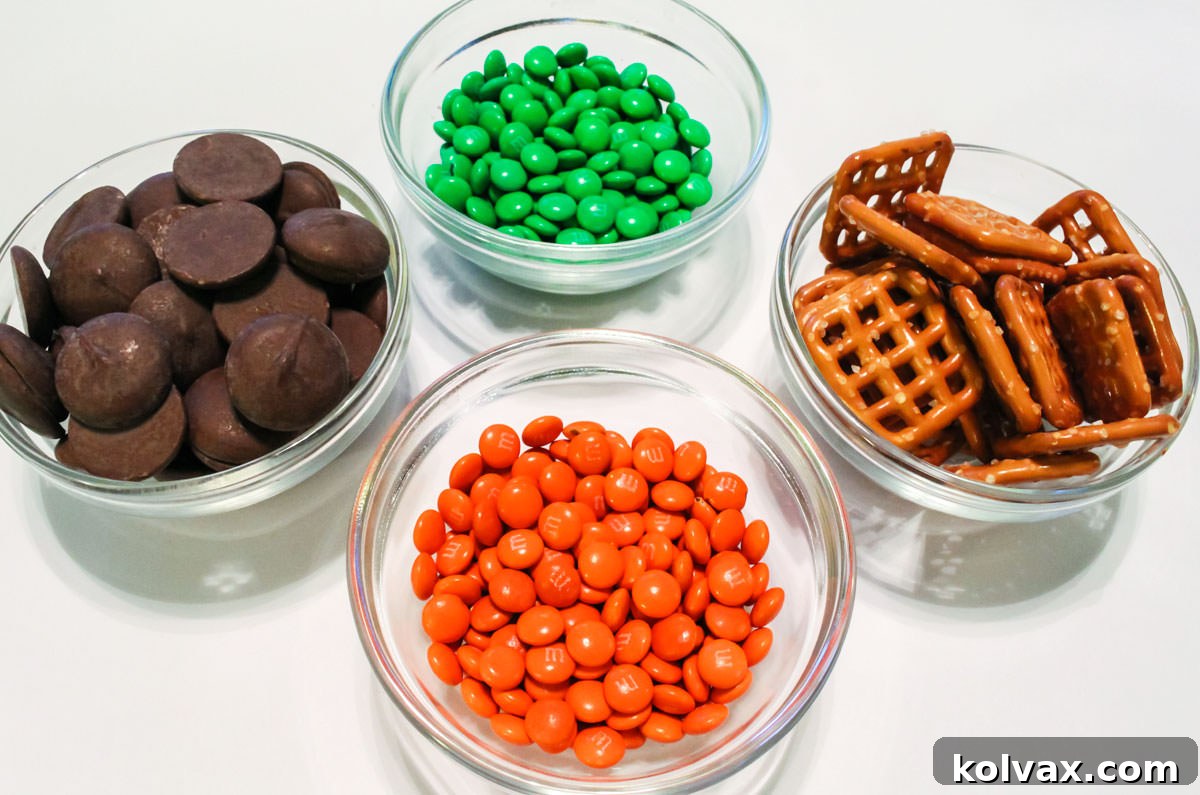 All the ingredients you will need to make Pumpkin Pretzel Bites including Pretzel Snaps, Chocolate Melting Wafers and Orange and Green Mini M&M's.