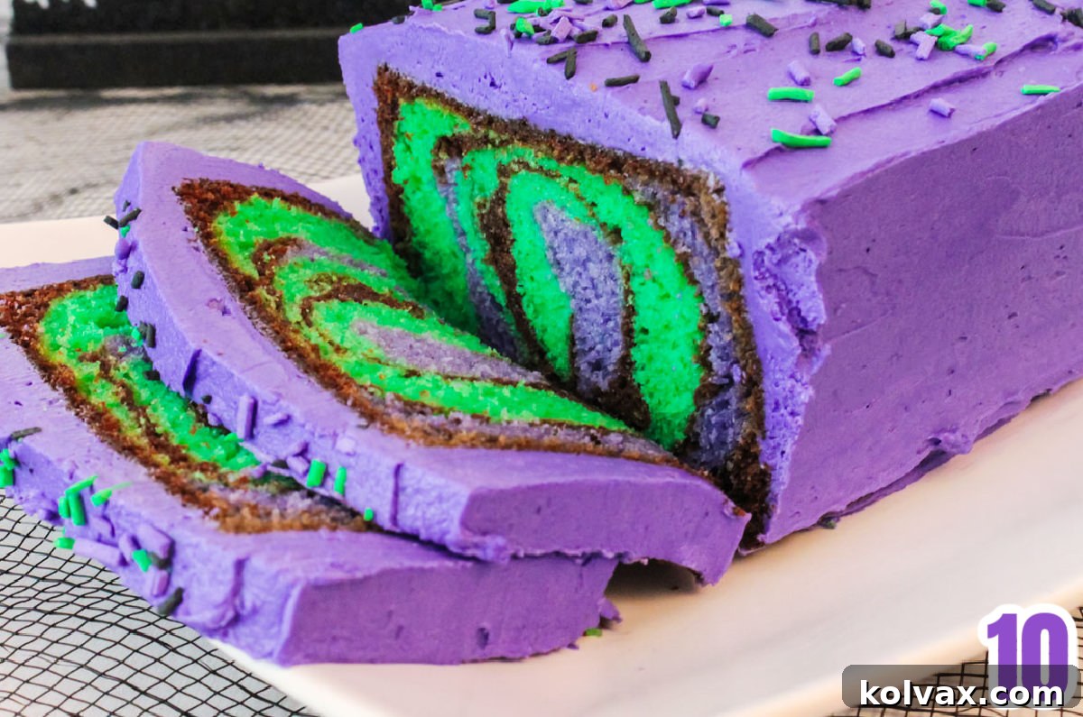 Closeup on a Halloween cake sitting on a white serving platter with slices cut to show the marble effect on the inside of the cake.