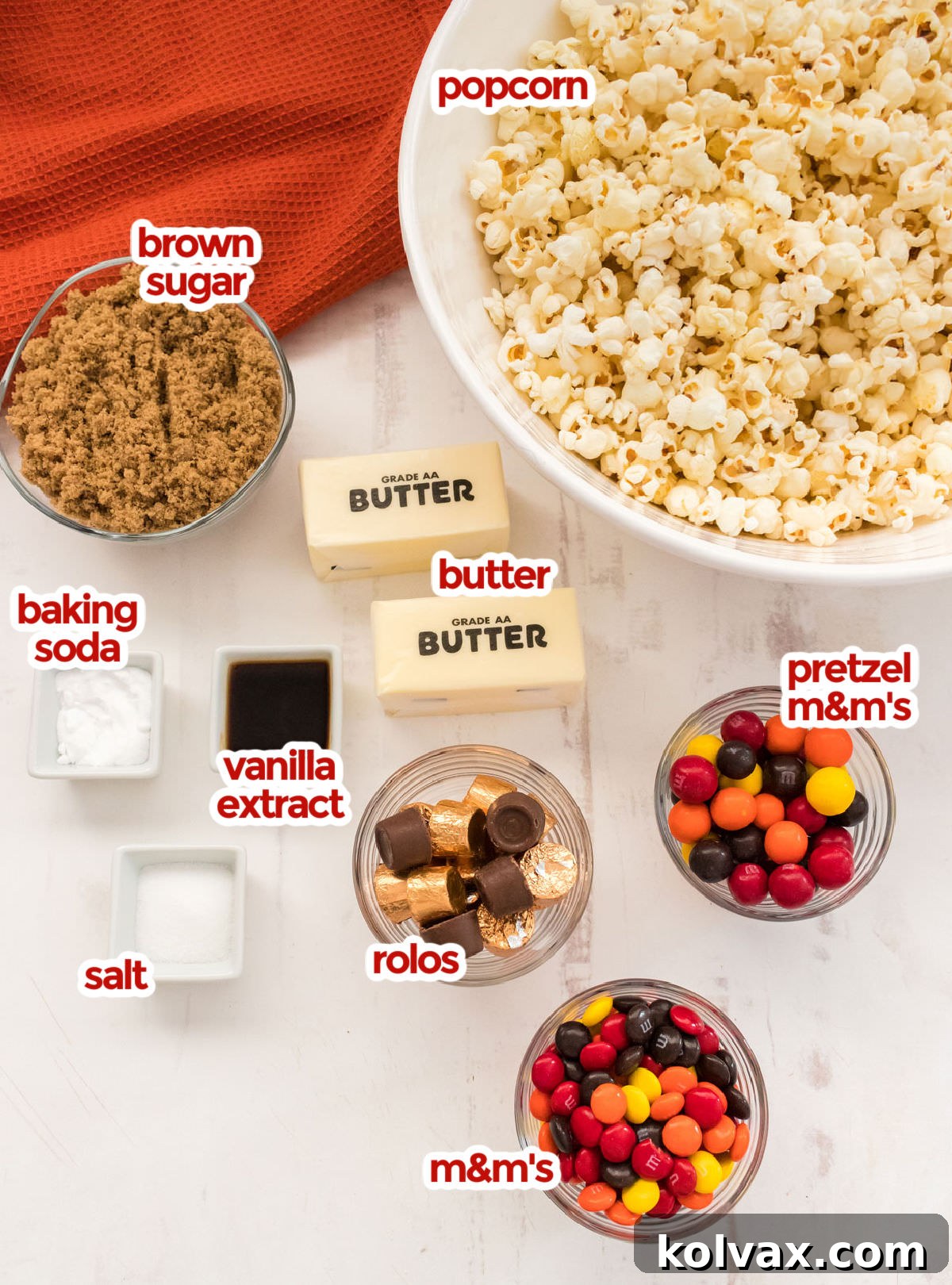 All the ingredients you will need to make Harvest Caramel Corn including popcorn, salt, brown sugar, butter, vanilla, baking soda, rolos, pretzel m&m's and regular m&m's.