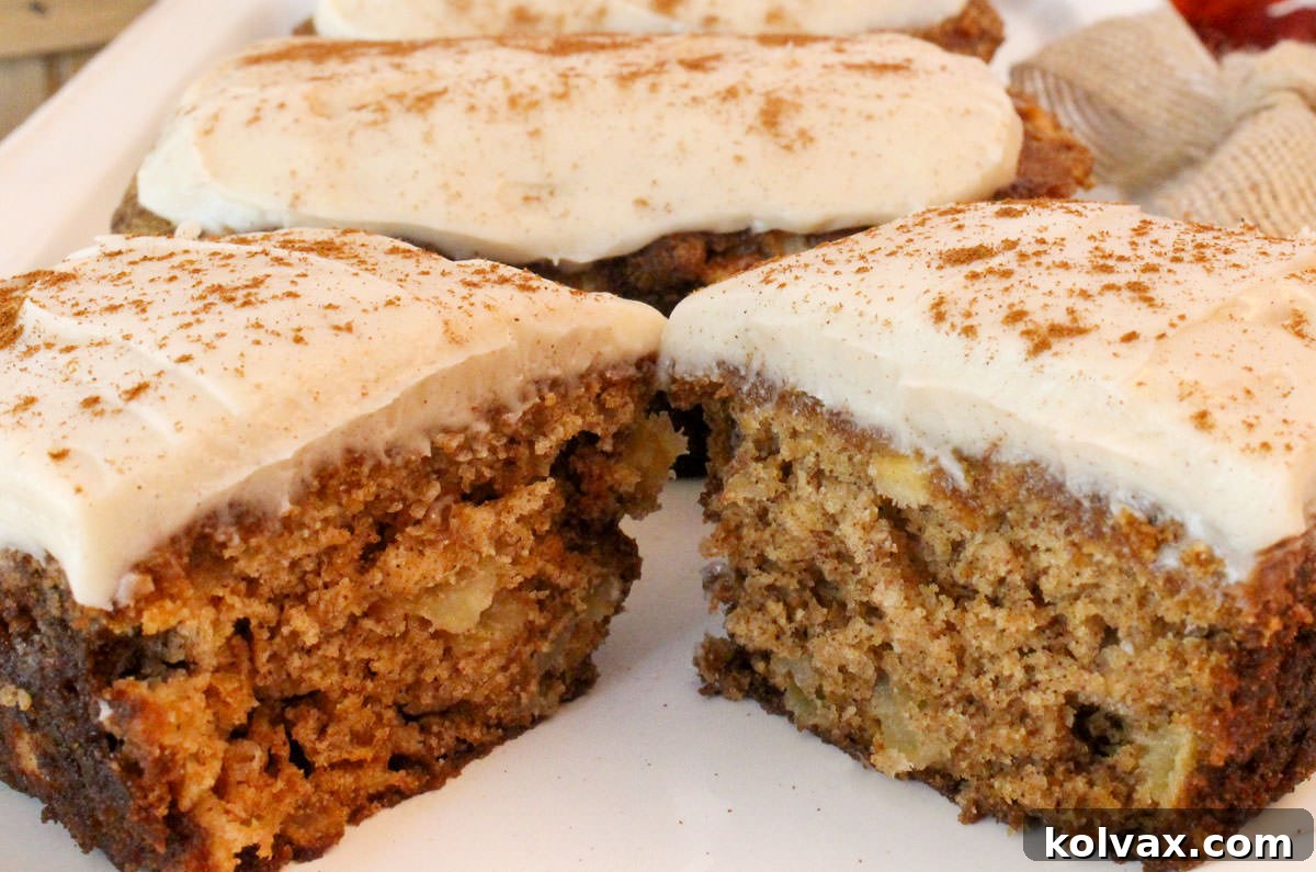 Close-up of freshly baked Apple Bread Mini Loaves, generously frosted with creamy Cream Cheese Frosting and lightly dusted with Cinnamon, showcasing their inviting texture and fall-inspired appeal.