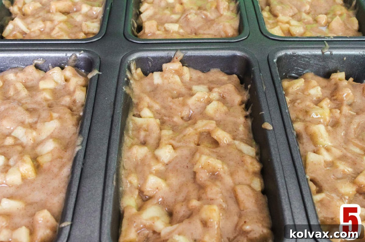 Close-up of a mini loaf pan filled with Apple Bread batter, ready to be placed into the oven for baking.