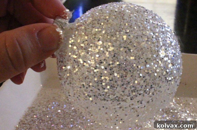 Sprinkling white and silver glitter generously over a Mod Podge-covered ornament.
