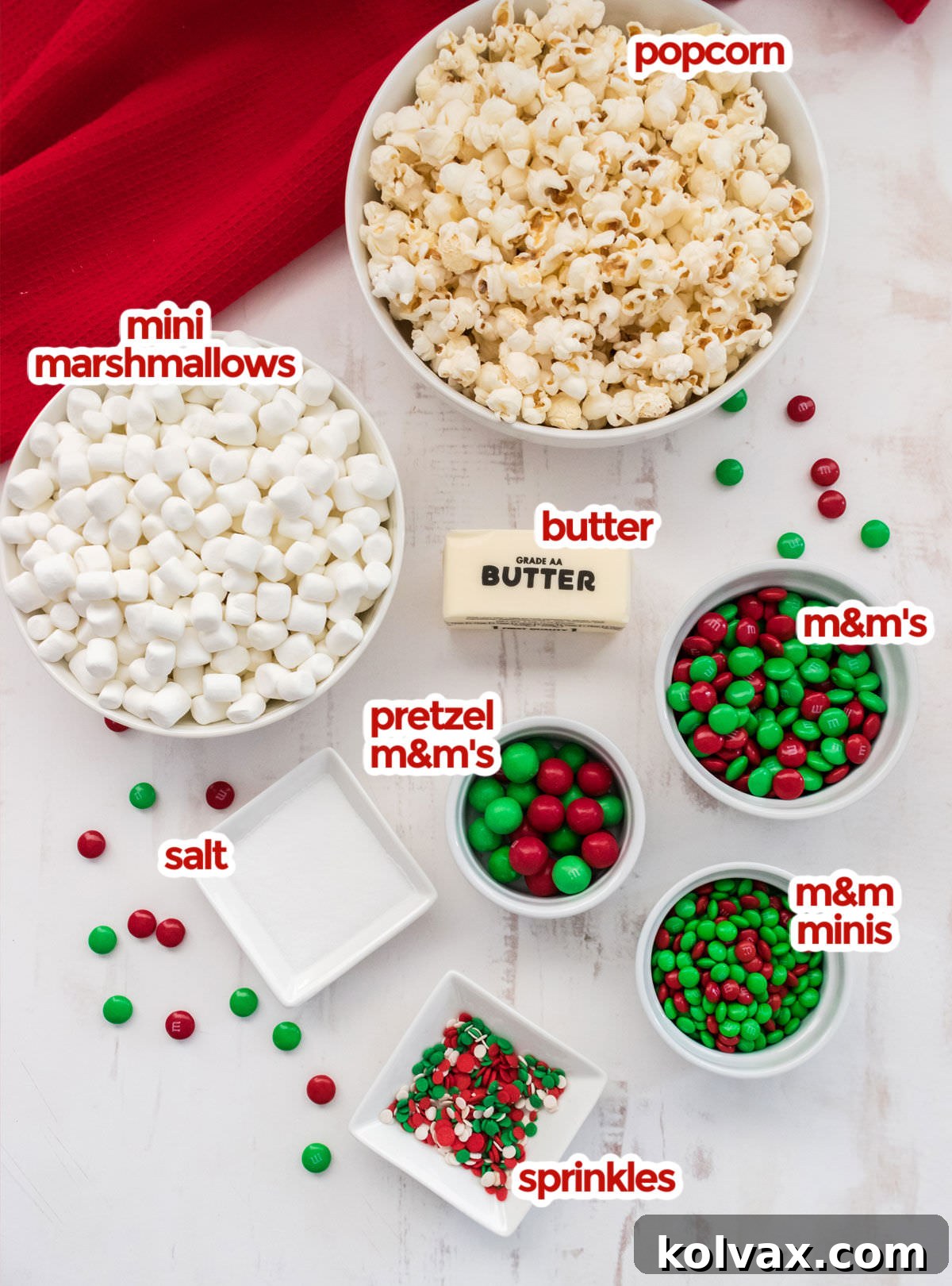 All the ingredients you will need to make Santa Crunch Popcorn including popcorn, mini marshmallows, butter, salt, sprinkles and various types of Red and Green M&M's.