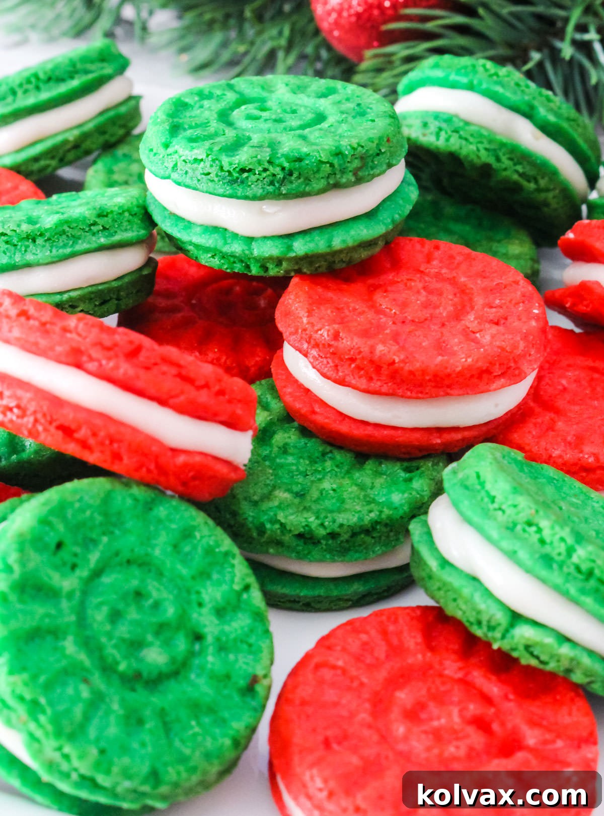 A close-up shot of a beautiful batch of Red and Green Christmas Sugar Cookie Sandwiches artfully arranged on a clean white surface.