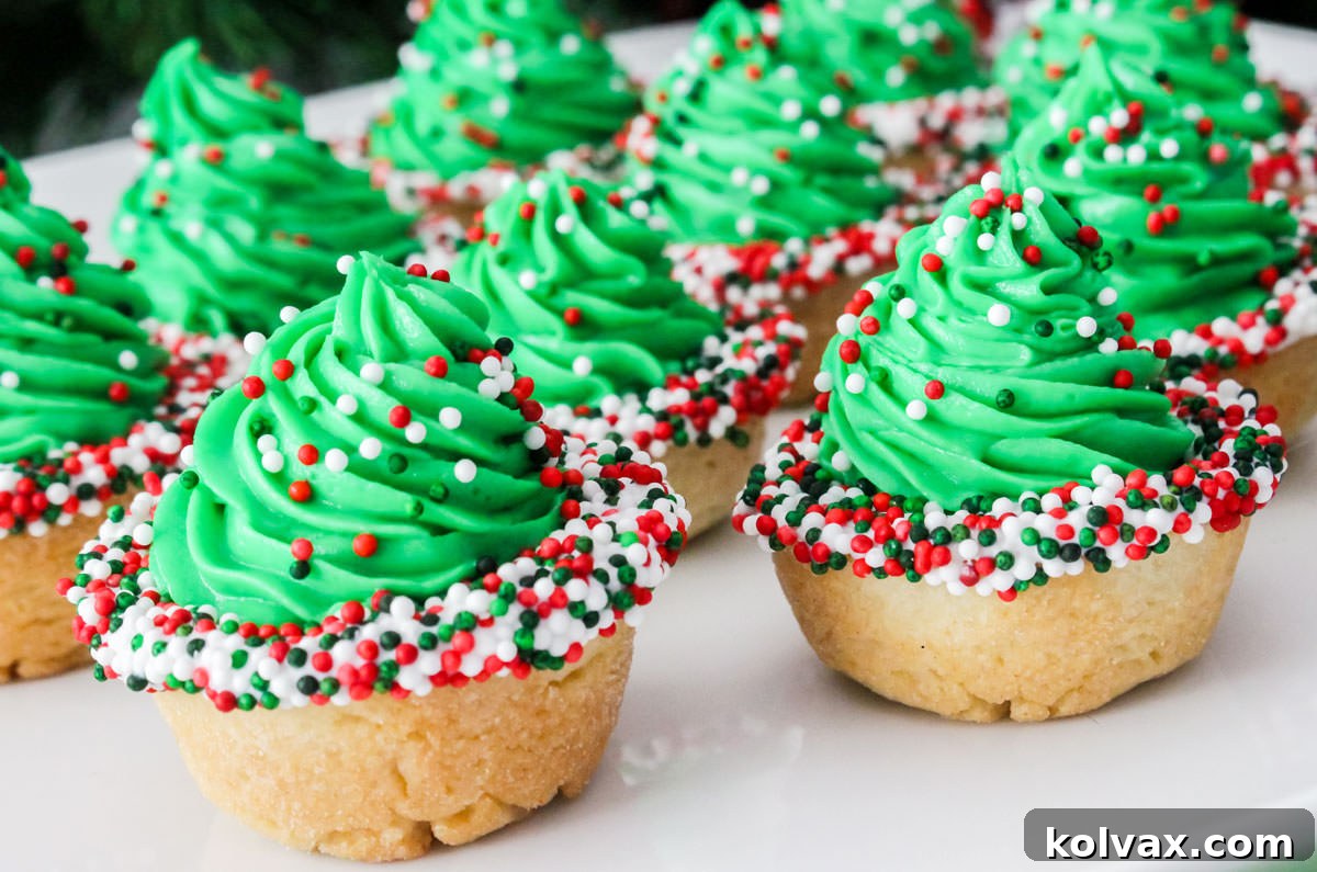 Closeup on a batch of Christmas Tree Cookie Cups on a white serving platter.
