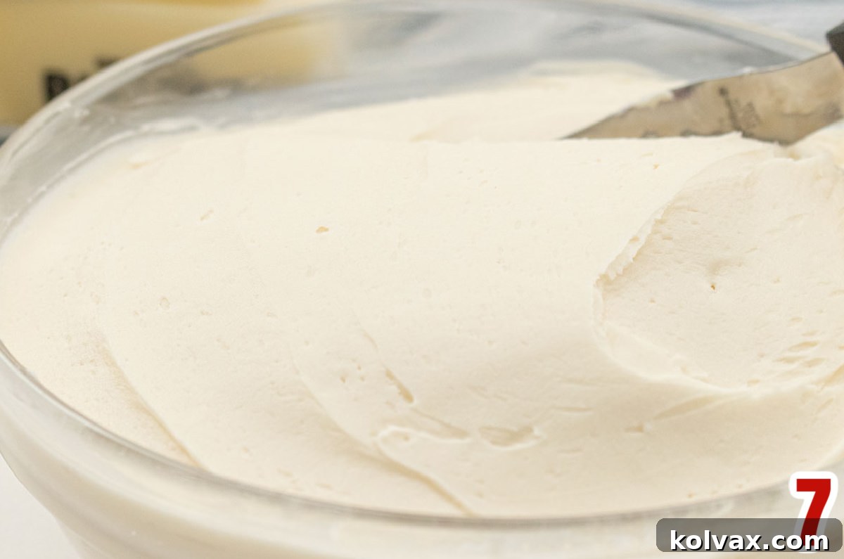 Closeup on a clear mixing bowl filled with homemade Buttercream Frosting.