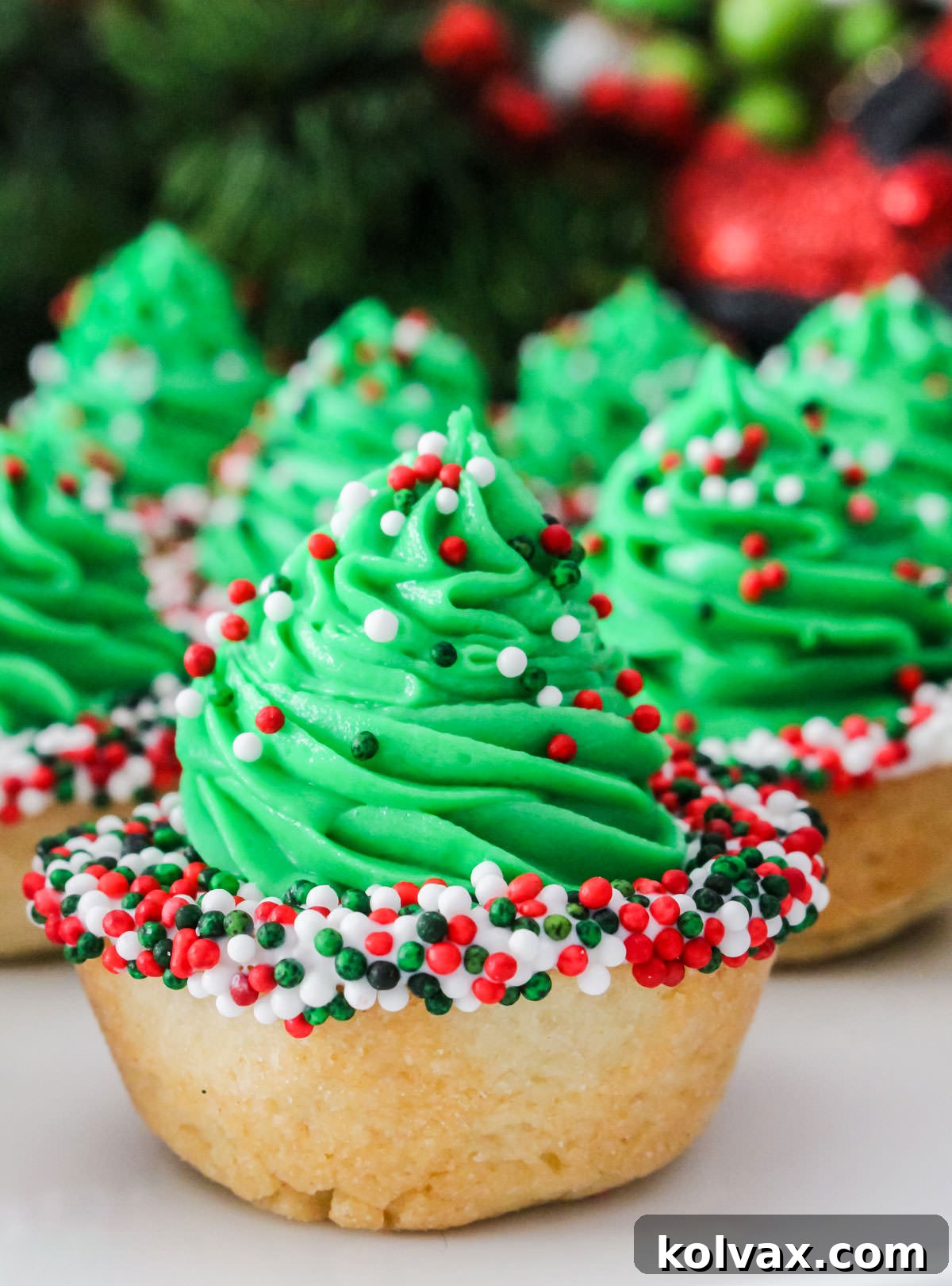 Closeup on a batch of Christmas Tree Cookie Cups sitting on a white table.