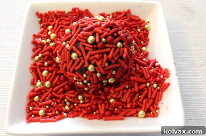 Chocolate cookie dough balls completely covered in a generous layer of shimmering holiday sprinkles.