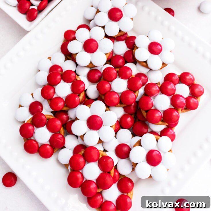 A batch of Holiday Poinsettia Pretzel Bites laying on a white dessert plate.