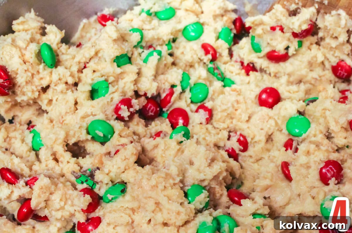 Closeup on the Christmas M&M Rice Krispie cookie dough in a metal mixing bowl.