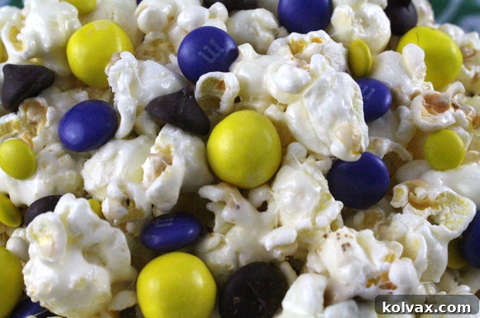Sprinkling assorted candies, including purple and yellow M&M's, onto warm marshmallow-coated Minnesota Vikings Popcorn.
