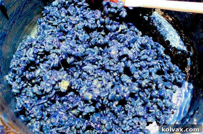 Blue Rice Krispie Cereal mixture in a bowl, ready to be molded into football jerseys.