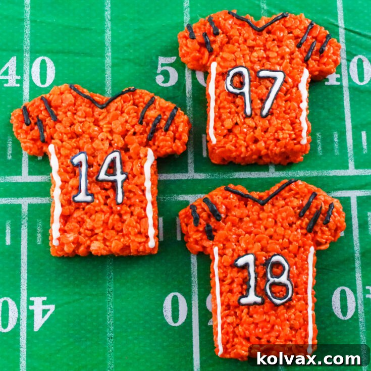 Festive Cincinnati Bengals Rice Krispie Treats shaped like jerseys, decorated with orange and black frosting and sprinkles.