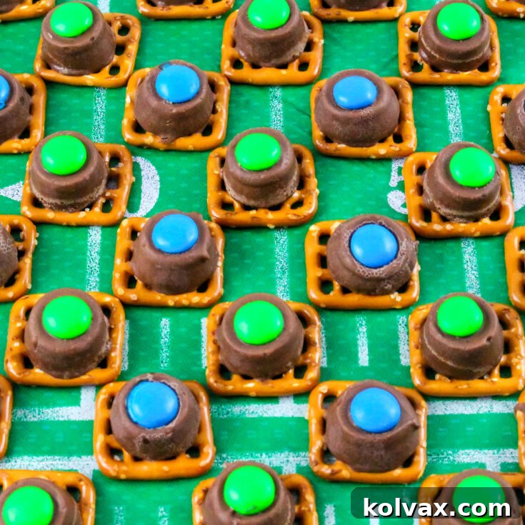 Closeup on a batch of Seattle Seahawks Pretzel Bites lined up in rows on a football themed table cloth, ready for serving at a party.
