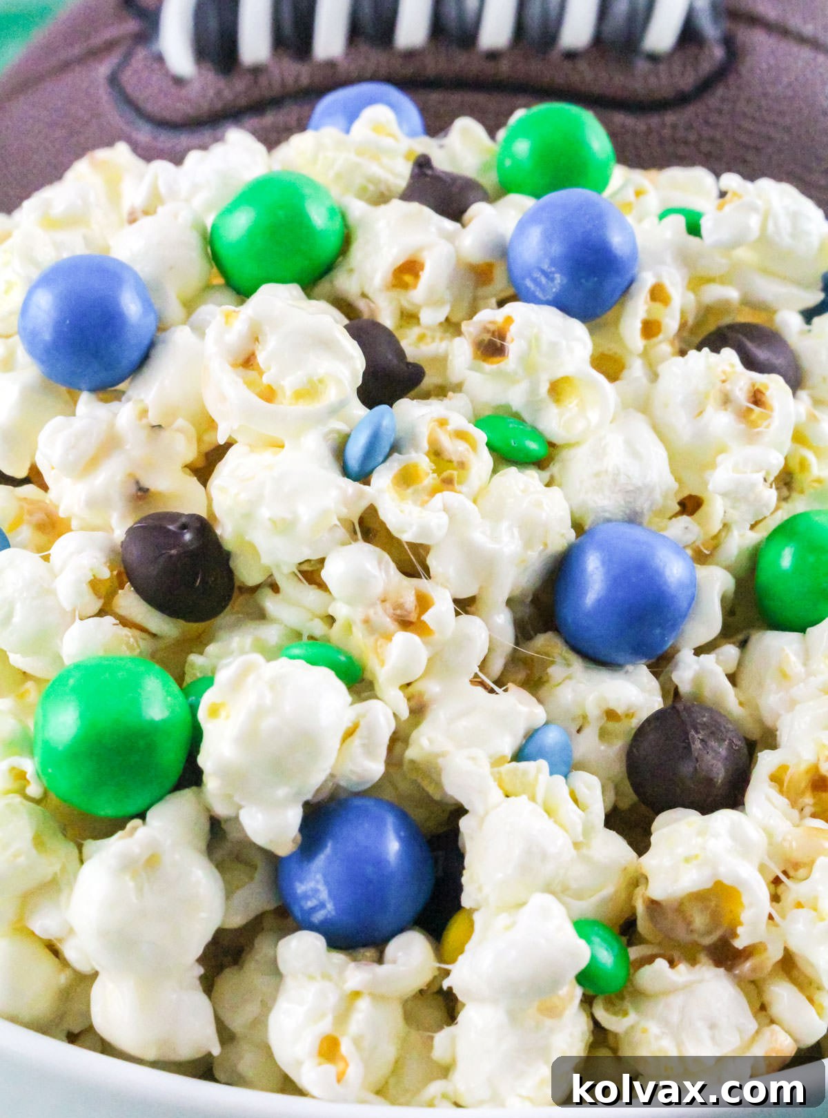Closeup on a white bowl filled with Seattle Seahawks Popcorn sitting in front of a football.