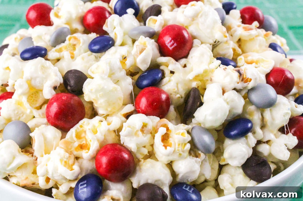 Closeup on a white serving bowl filled with vibrant New England Patriots Popcorn, featuring red, navy, and grey candies.