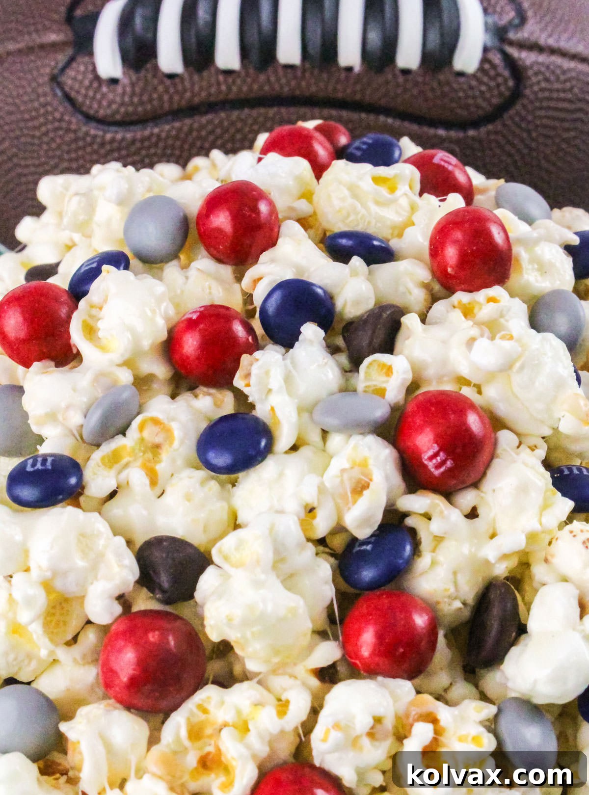 Closeup on a white bowl filled with New England Patriots Popcorn, casually positioned in front of a classic football.