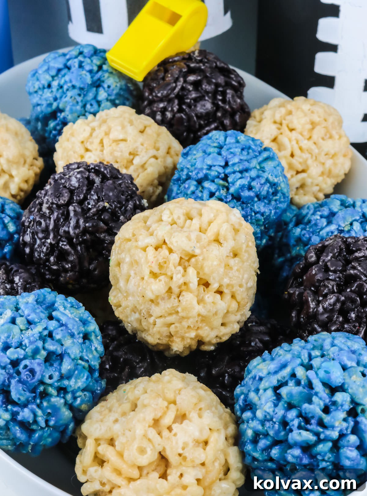 A bowl filled with small, colorful Carolina Panthers Rice Krispie Bites, presented with football-themed decorations.