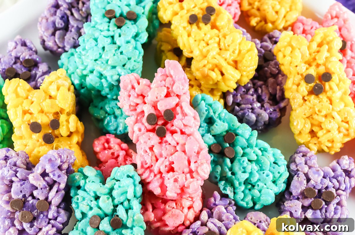 A close-up view of a cheerful pile of pastel-colored Rice Krispie Easter Bunny Peeps, each adorned with tiny chocolate chip noses, ready to celebrate Easter.