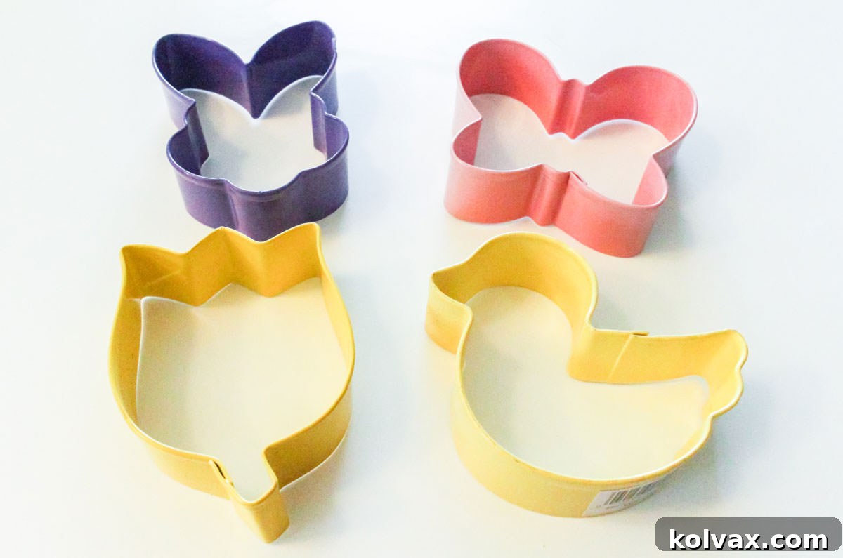 Close up on a grouping of four springtime cookie cutters including a bunny, a butterfly, a tulip and a ducky.