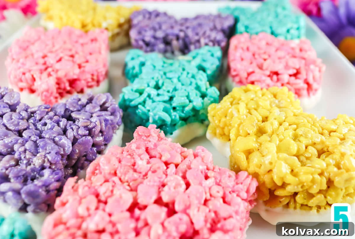Close up on the bottoms of colored Rice Krispie Treats that have been dipped in White Chocolate.